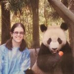 photo of Amy Detwiler sitting next to a panda eating a carrot